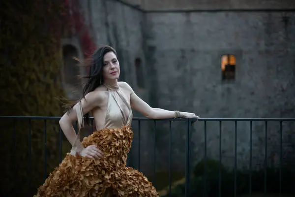 İspanyol kalesinin önünde poz veren zarif bir elbise giymiş bir kadın..