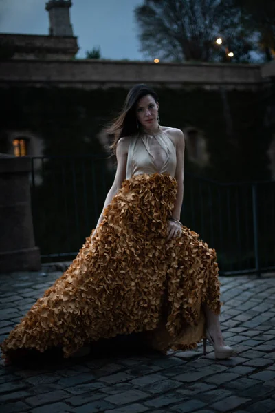 İspanyol kalesinin önünde poz veren zarif bir elbise giymiş bir kadın..