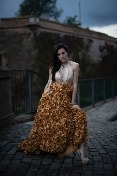 İspanyol kalesinin önünde poz veren zarif bir elbise giymiş bir kadın..