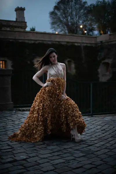 İspanyol kalesinin önünde poz veren zarif bir elbise giymiş bir kadın..