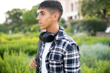 Sırt çantalı genç uluslararası bir öğrenci okula gidiyor..