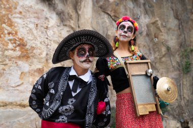 Müzik aletleriyle mandalina gibi giyinmiş Meksikalı bir çiftin portresi
