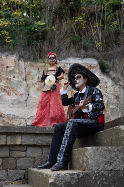 Müzik aletleriyle mandalina gibi giyinmiş Meksikalı bir çiftin portresi