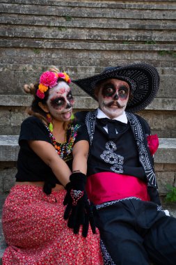 Catrine gibi giyinmiş komik suratlar yapan bir çift genç.