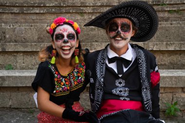 Mancınık gibi giyinmiş, kameraya gülümseyen birkaç genç.