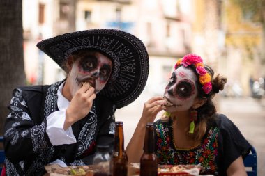 Meksika usulü şık giyinmiş ve taco yiyen bir çift.