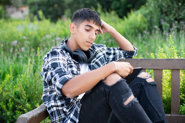 Kampüsteki genç uluslararası öğrenci açık havada okuyor..