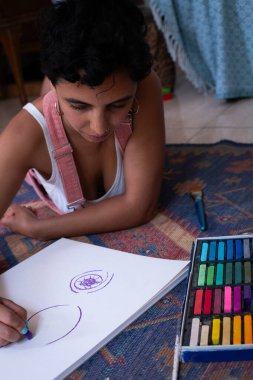 Pastalarla Boş bir tuvale Göz Boyayan Genç Kadın