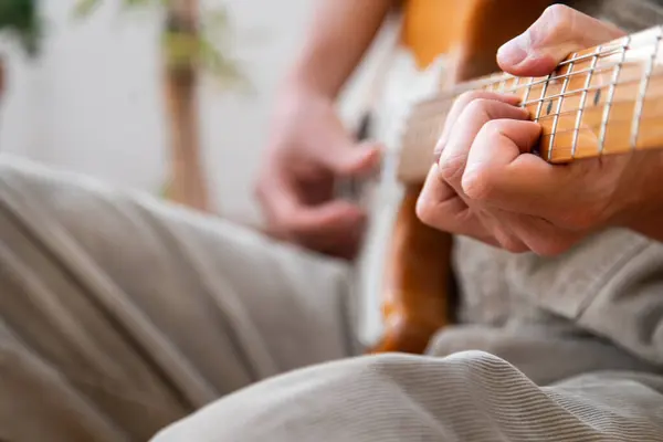 Terasında sarı gitar çalan genç bir gitarist..