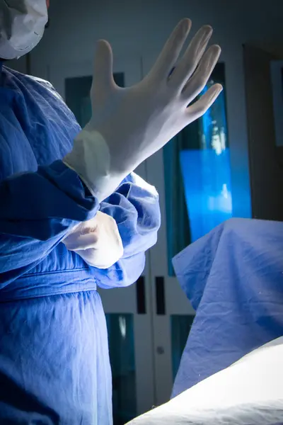 Cerrah ameliyat eldivenlerini takıyor.