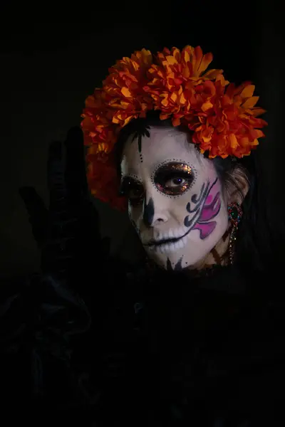 Bir Catrina 'nın yakın plan portresi, güzel yapılmış makyajını koyu bir arka planda gösteriyor. Sadece yüzüne odaklanarak makyajının karmaşık detaylarını ve sanatını vurgulayarak bu geleneksel figürün özünü yakalıyor..