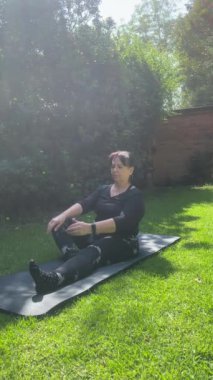 Yoga minderi üzerinde sol bacağa doğru gerinen kadın (Yan Görünüm)