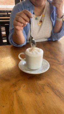 Ahşap Masa 'da mükemmel bir cappuccino karıştırmak