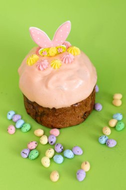 Süslü Paskalya pastası, tavşan kulakları ve pastel kremalı ve küçük şeker yumurtalarıyla çevrili..
