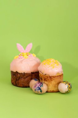 Geleneksel Ukrayna paskalya pastaları çiçek desenli yumurtalarla çevrili, canlı yeşil bir arka planda duruyorlar..