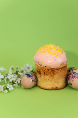 Pastırmalı tek Paskalya pastası ve çiçek desenli yumurtalar çiçek açan kiraz çiçeklerinin yanına.