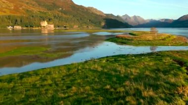 Eilean Donan Kalesi 4K 'da kuşlarla alçak pas atıyor. Yüksek kalite 4k görüntü