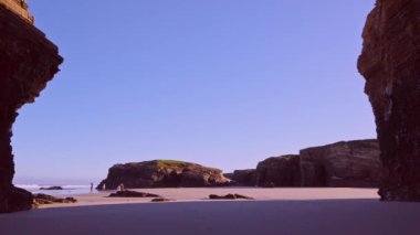İki ebeveyn katedral sahilinde spor yaparken bir kız ve bir erkek bir kayanın arkasına saklanıyorlar..