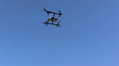 Gökyüzündeki insansız hava aracı, teknolojinin tamamen mavi bir arka planla görülebileceği bir yerde..