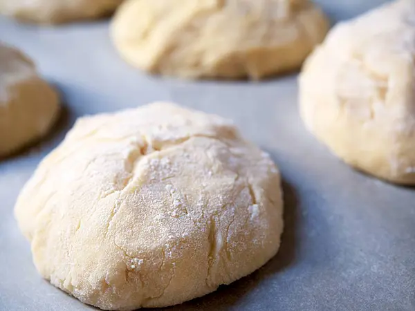 place the dough in the shape of buns on a baking sheet