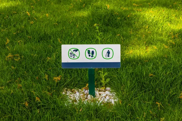 Sign do not walk on the lawn do not litter and pluck plants