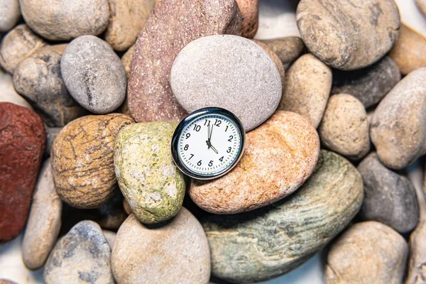 Clock with time on stones for the concept of relaxation or moving forward and motivation