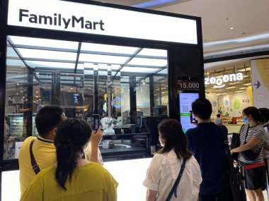 İnsanlar Family Mart, Jakarta, Endonezya 'da robotlar tarafından sunulan kahveyi hevesle alıyorlar.