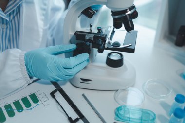 Kimyager laboratuvarda bir deney yapıyor, bir bilim adamı kimyasal bileşimi analiz etmek için mikroskop kullanıyor, bilimsel bir deney laboratuvarda biyolojik cevaplar arıyor.,