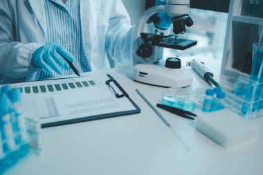 Kimyager araştırma verileri üzerine notlar alıyor, bilim adamı laboratuvarda çalışıyor, Kimyager deneysel sonuçları analiz ediyor ve laboratuvar, laboratuvar fikri üzerine notlar alıyor..