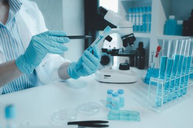 Kimyager test tüplerini kimyasal olarak analiz ediyor. Bilim adamı laboratuvarda kimyasallar üzerinde deney yapıyor. Kimyager test tüplerindeki bileşikleri kimyasal reaktörlerle ayırıyor.,