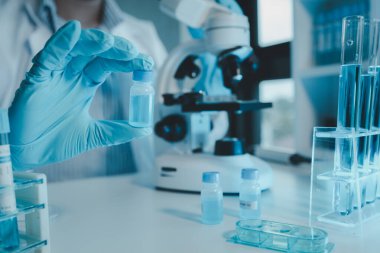 Kimyager laboratuvarda bir deney yapıyor, bir bilim adamı kimyasal bileşimi analiz etmek için mikroskop kullanıyor, bilimsel bir deney laboratuvarda biyolojik cevaplar arıyor.,