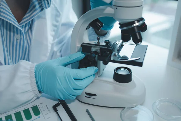 Kimyager laboratuvarda bir deney yapıyor, bir bilim adamı kimyasal bileşimi analiz etmek için mikroskop kullanıyor, bilimsel bir deney laboratuvarda biyolojik cevaplar arıyor.,