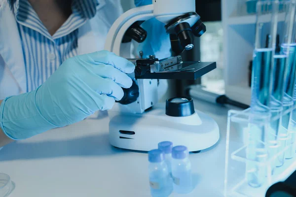 Kimyager laboratuvarda bir deney yapıyor, bir bilim adamı kimyasal bileşimi analiz etmek için mikroskop kullanıyor, bilimsel bir deney laboratuvarda biyolojik cevaplar arıyor.,