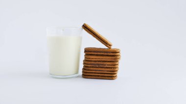 Bir bardak süt ve çikolatalı bisküvi. Bir yığın lezzetli kek. Çikolata dolu kare bisküviler ve fotokopi alanı. beyaz arkaplanda izole