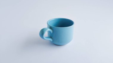 Beyaz arka planda mavi kahve fincanı, sofra takımı ve masa aksesuarları