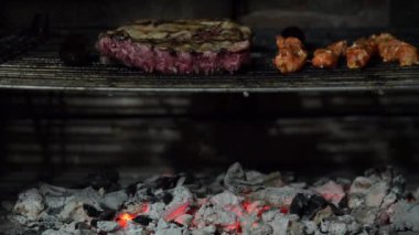 Domuz pirzolası ve ızgarada mangal kömürü üzerinde pişen salamura tavuk şişleri.