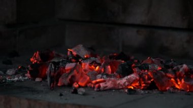 Kömür közleri parlıyor ve bir adam ızgarayı yerleştirirken lezzetli bir barbekü yapmaya hazır.