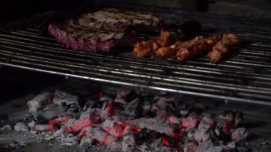 Domuz pirzolası ve ızgarada mangal kömürü üzerinde pişen salamura tavuk şişleri.