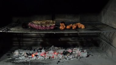 Domuz pirzolası ve ızgarada mangal kömürü üzerinde pişen salamura tavuk şişleri.