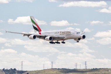 Madrid, İspanya; 05-18-2024: Emirates havayolu uçağı ve Airbus A380 modeli iniş takımlarının açılmasıyla iniş manevrasına başladılar