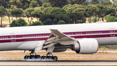 Madrid, İspanya; 05-18-2024: Katar Havayolları şirketinin bir Boeing 777 'sinin iniş takımlarına yakın çekim, pistin asfaltına temas ettiği anda tekerleklerde dumana neden oluyor.