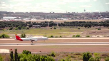 Madrid, İspanya; 05-18-2024: İspanya 'nın Iberia havaalanına iniş yapan İberya Airbus A321 modelinin ticari uçağı, iş alanının beş kulesiyle birlikte Madrid' e indi.