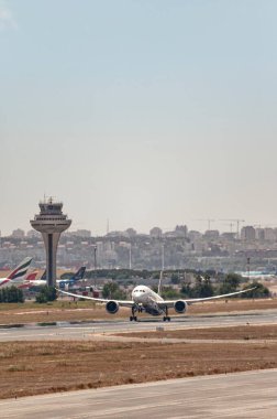 Madrid, İspanya; 05-24-2024: Boeing 787 model Şili modeli uçak kalkış manevrasına iniş takımlarının açılmasıyla ve havaalanı kontrol kulesinin arkasından başlıyor
