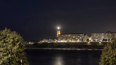 A Coruna 'daki Riazor plajının gece manzarası ve Herkül Kulesi feneri parlıyor.