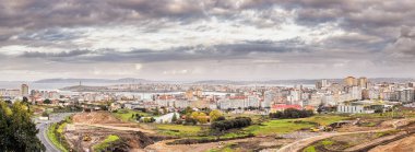 Panoramic view of the Galician city of A Coruna with Riazor beach and the Tower of Hercules on a cloudy day typical of northern Spain clipart