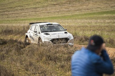 Madrid, İspanya; 02-15-2025: Hyundai i20N Rally2 'nin bir ralli pistinde hız yaparken ön planda bulanık izleyici