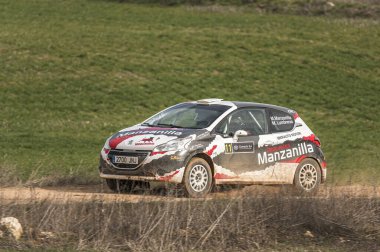 Madrid, İspanya; 02-15-2025: Peugeot 208, tozlu bir pistte ustalıkla viraja girdi, hassasiyet kontrolü ve ralli yarışlarının heyecanını gösteriyordu