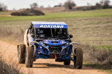 Madrid, İspanya; 02-15-2025: Can-Am Maverick X3 at arabası toprak yolda hızlanıyor, çevik manevraları ve toz izleri off-road yarışlarının maceracı ruhunu vurguluyor