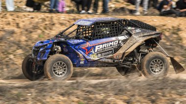 Madrid, İspanya; 02-15-2025: Can-Am Maverick X3 at arabası toprak yolda hızlanıyor, çevik manevraları ve toz izleri off-road yarışlarının maceracı ruhunu vurguluyor