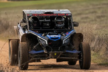 Madrid, İspanya; 02-15-2025: Can-Am Maverick X3 at arabası toprak yolda hızlanıyor, çevik manevraları ve toz izleri off-road yarışlarının maceracı ruhunu vurguluyor